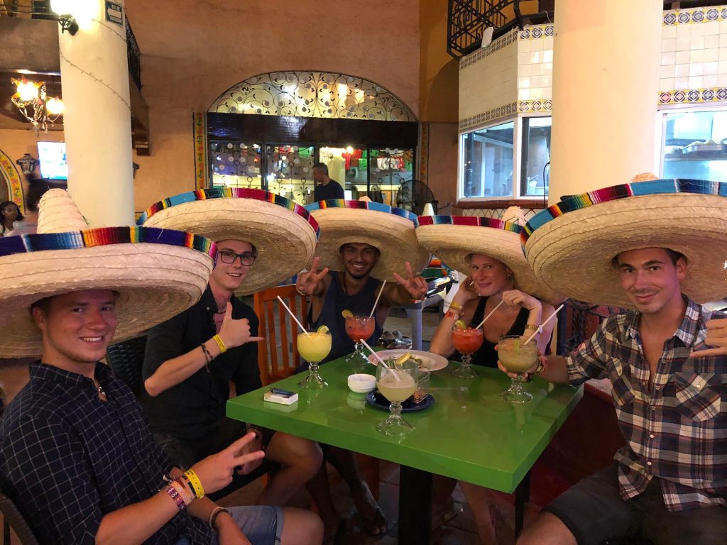 Moving to another city: 5 friends with Mexican hats and drinks