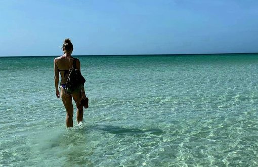 Living the nomadic lifestyle: a girl walking in the sea