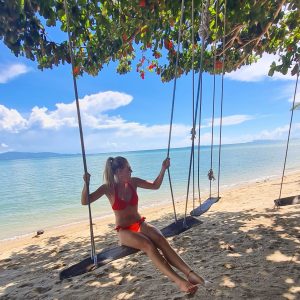 A girl on a swing on a beach in Thailand - Digital nomadism