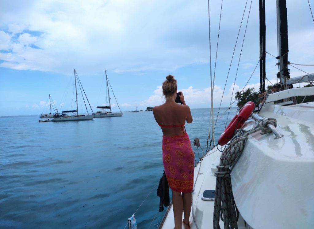 A girl on a boat taking a picture while on a long term travel trip