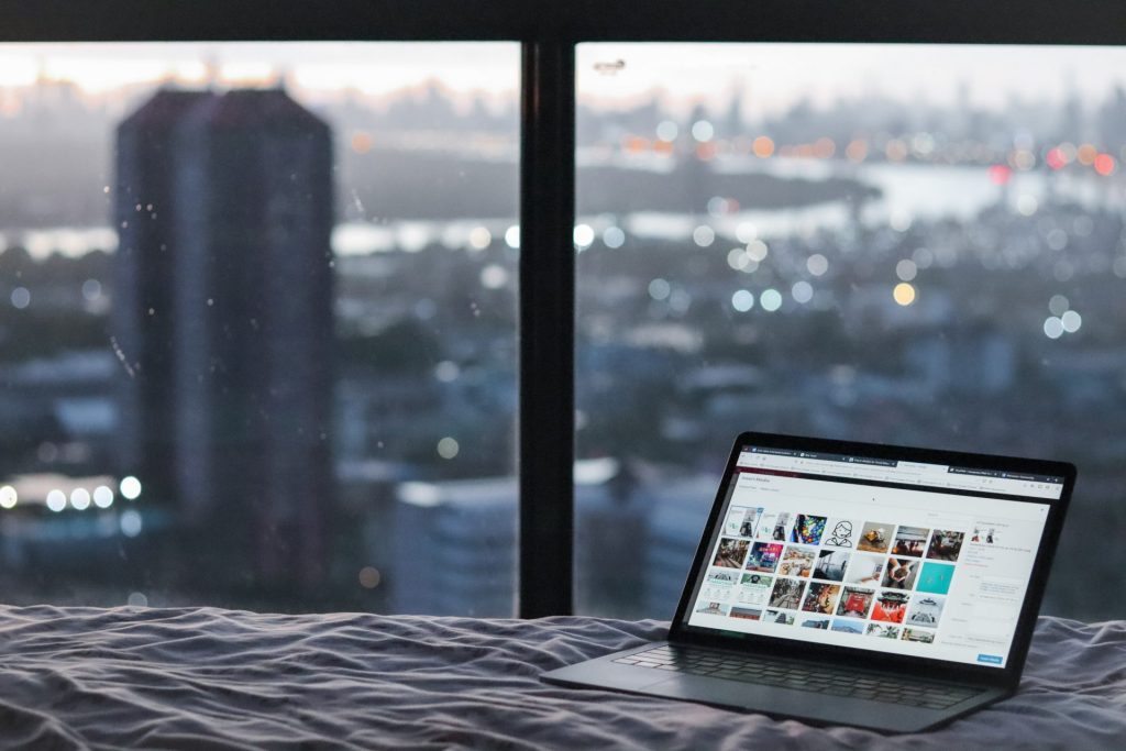 Becoming a digital nomad means working and travelling in new cities: picture of a laptop and city view