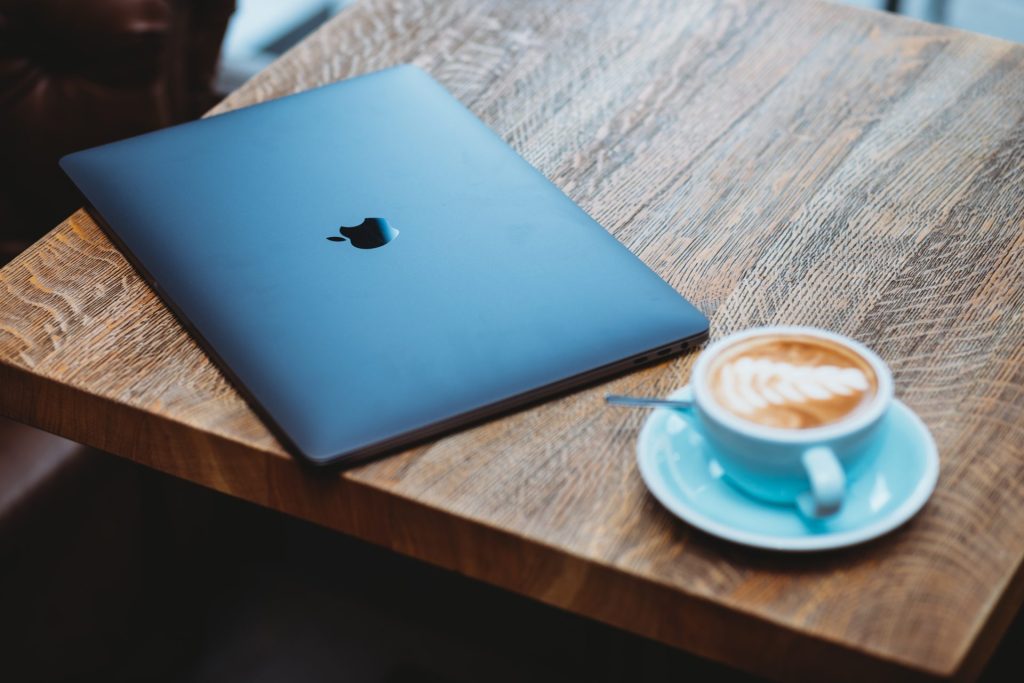 A laptop and coffee representing the digital nomad life in coffee shops